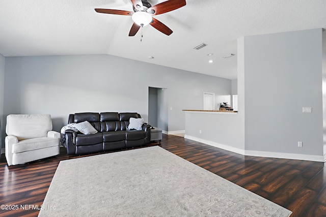 living area featuring vaulted ceiling, wood finished floors, and visible vents