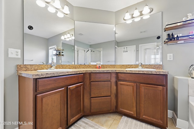 bathroom with a shower stall, double vanity, and a sink