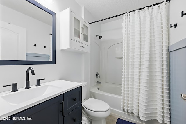 bathroom with a textured ceiling, shower / bath combo, vanity, and toilet