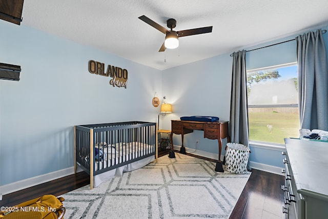 bedroom with baseboards, multiple windows, and wood finished floors