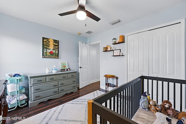 bedroom with visible vents, a closet, and dark wood-style floors