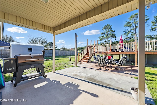 view of patio featuring an outbuilding, a fenced backyard, stairway, a grill, and a wooden deck