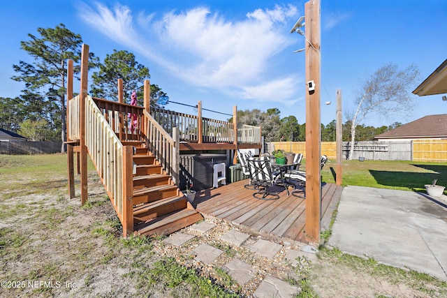 wooden terrace featuring a yard, a fenced backyard, and stairway