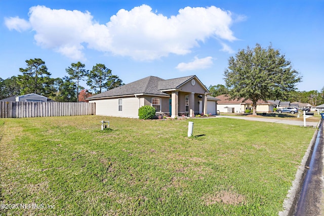 view of front of home with stucco siding, driveway, fence, a front yard, and a garage