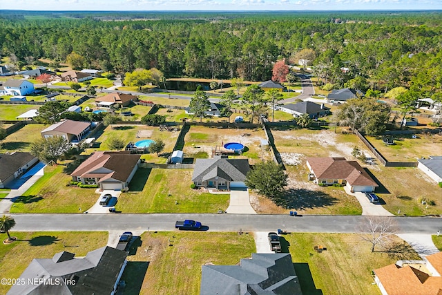 birds eye view of property featuring a wooded view and a residential view