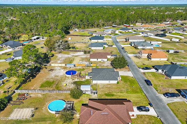 drone / aerial view with a residential view and a wooded view