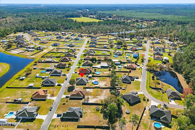 bird's eye view with a wooded view, a water view, and a residential view