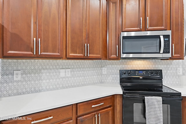 30302 Trophy Trl, Bryceville, FL 32009 - kitchen featuring brown cabinets, light countertops, stainless steel microwave, decorative backsplash, and black electric range