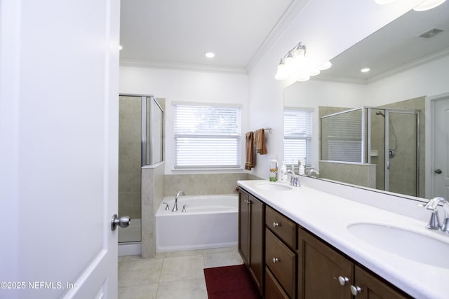 full bathroom featuring tile patterned flooring, ornamental molding, a stall shower, and a sink