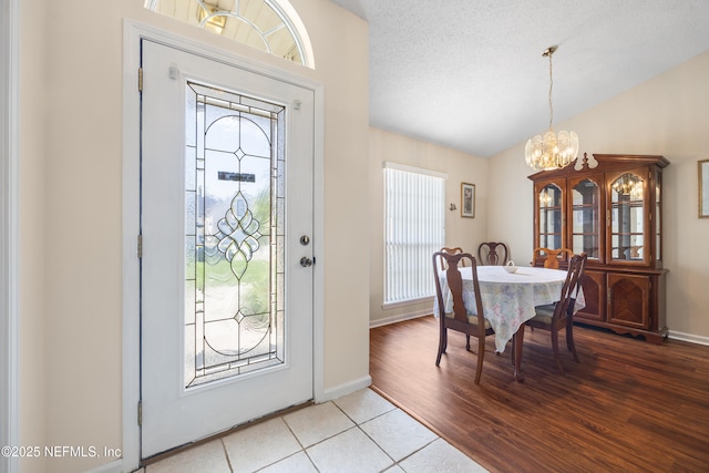 2017 Belhaven Dr, Orange Park, FL 32065 - entryway featuring baseboards, an inviting chandelier, lofted ceiling, light wood-style floors, and a textured ceiling