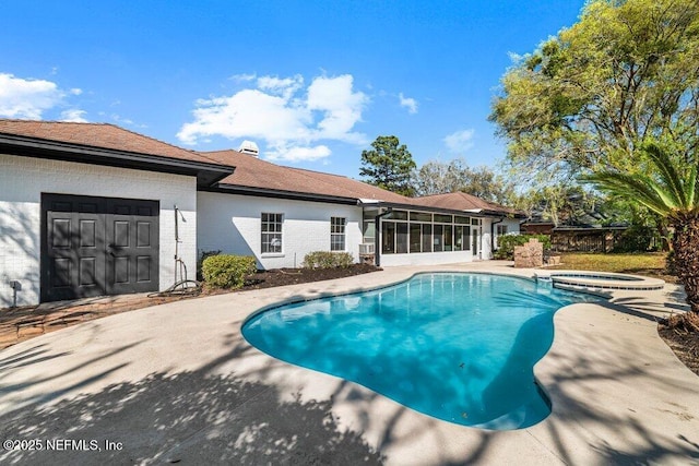 view of pool with a patio, a pool with connected hot tub, and a sunroom