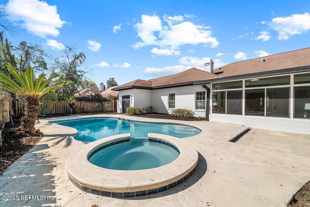 view of pool with a sunroom, a pool with connected hot tub, a patio, and fence