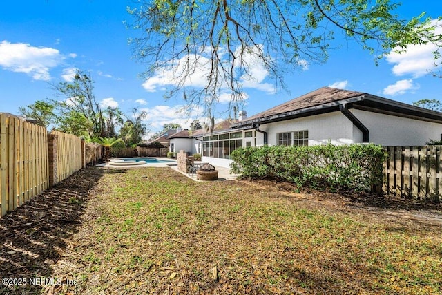 view of yard with a fenced in pool, a fenced backyard, and a sunroom