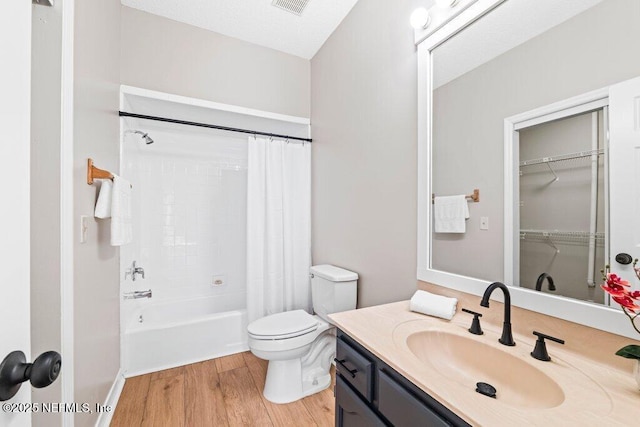 bathroom with shower / tub combo with curtain, toilet, wood finished floors, and vanity