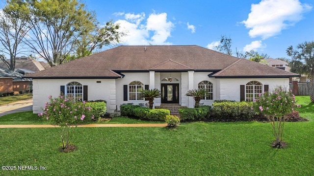 view of front of home featuring stucco siding, a front lawn, and a shingled roof