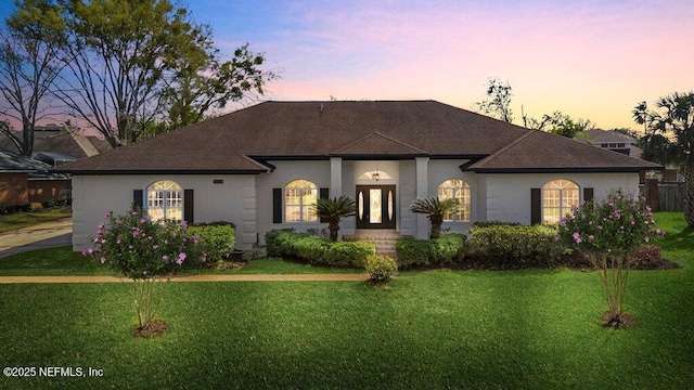 view of front facade with stucco siding and a front yard