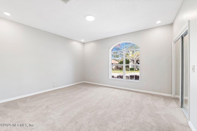 unfurnished bedroom featuring baseboards, recessed lighting, a textured ceiling, and carpet