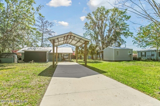 surrounding community featuring concrete driveway, a yard, and a carport