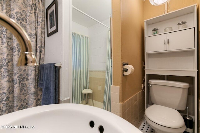 bathroom with a shower with shower curtain, toilet, and tile walls