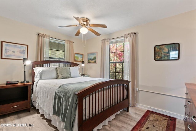 bedroom with wood finished floors, baseboards, and ceiling fan