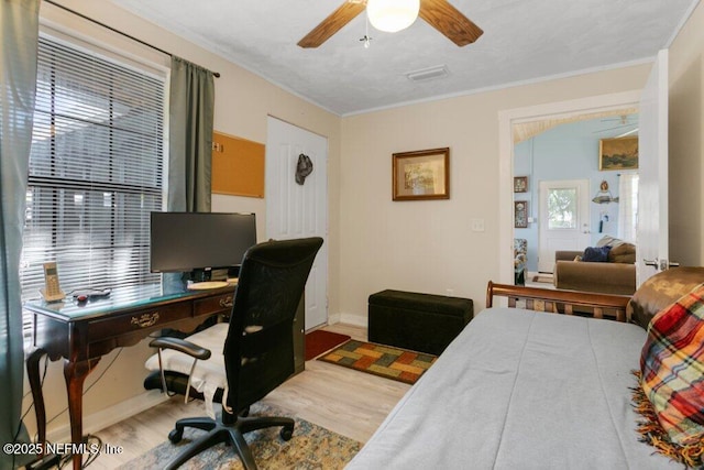 bedroom with baseboards, ceiling fan, and wood finished floors