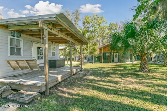 view of yard featuring an attached carport and a wooden deck