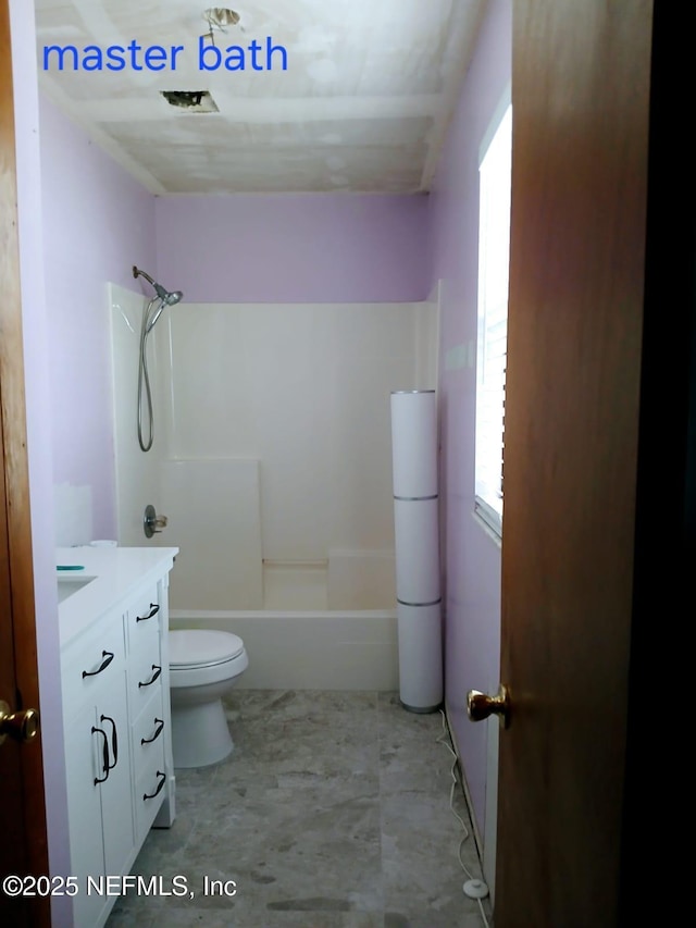 bathroom featuring toilet, vanity, and shower / bathing tub combination