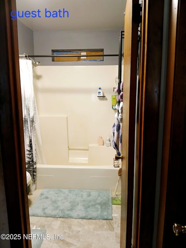 bathroom featuring shower / bathtub combination with curtain and toilet