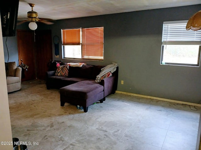 living room with baseboards, a wealth of natural light, and ceiling fan