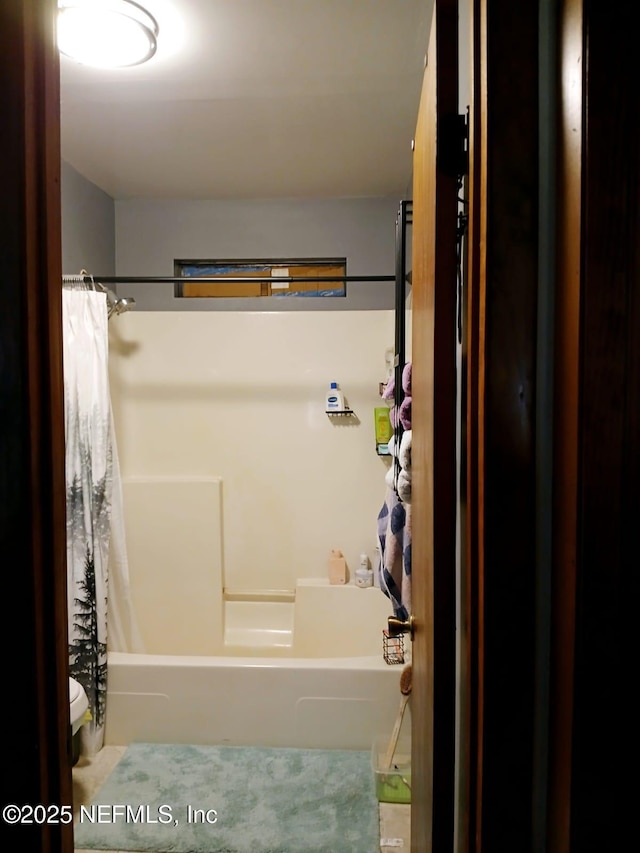 full bathroom with shower / bath combo with shower curtain and toilet