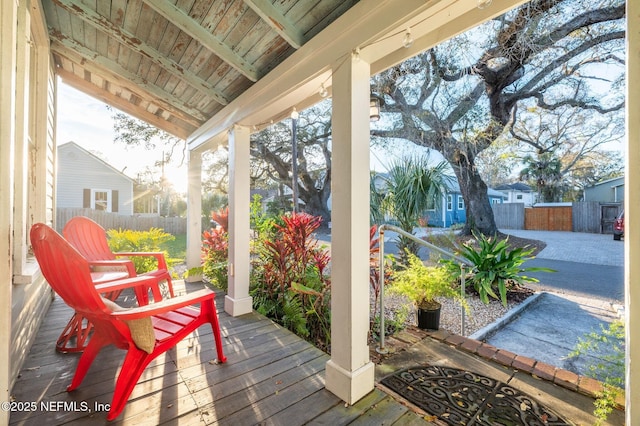 exterior space featuring a porch and fence