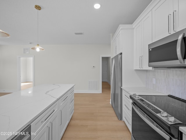 kitchen with visible vents, pendant lighting, white cabinetry, appliances with stainless steel finishes, and light wood finished floors