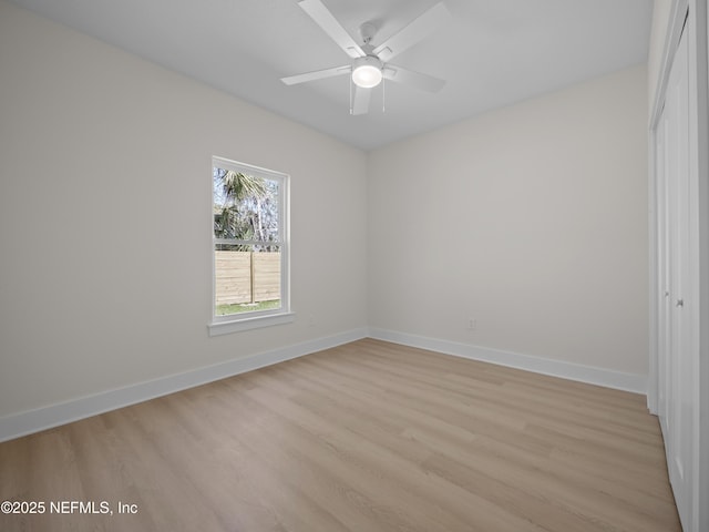 unfurnished room with baseboards, light wood-style flooring, and a ceiling fan