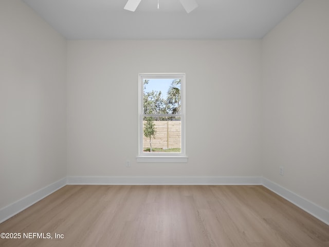 unfurnished room with baseboards, light wood-style floors, and ceiling fan