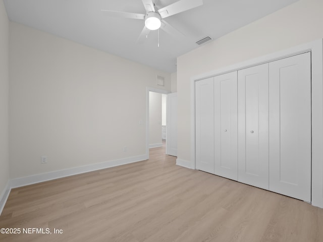 unfurnished bedroom featuring a closet, visible vents, baseboards, and light wood-style floors