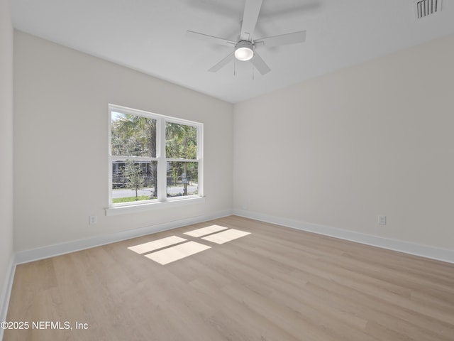 spare room featuring ceiling fan, baseboards, visible vents, and light wood-type flooring