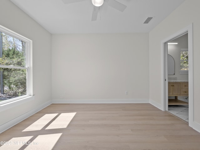 unfurnished room featuring visible vents, baseboards, light wood-style floors, and a ceiling fan