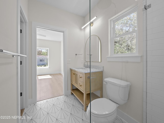 bathroom with toilet, vanity, and baseboards