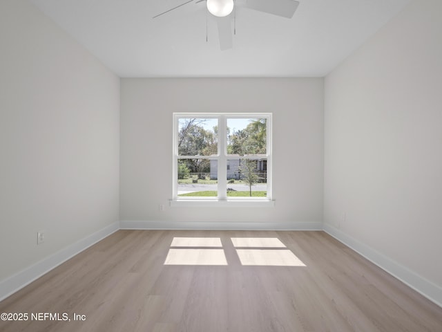 spare room featuring baseboards, a ceiling fan, and light wood finished floors