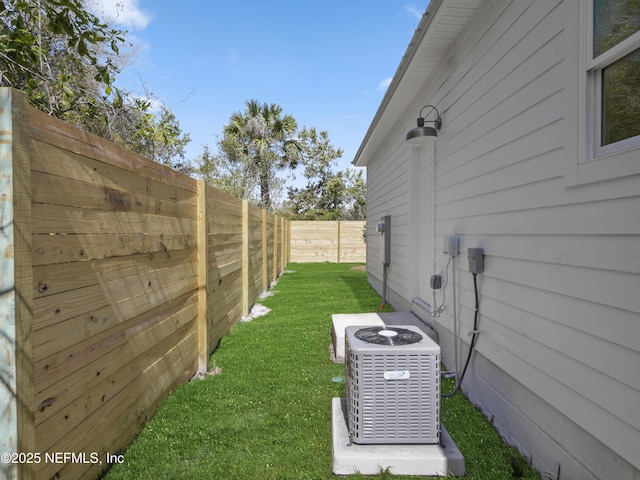 view of yard with central AC unit and a fenced backyard