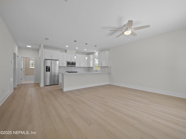 kitchen with tasteful backsplash, ceiling fan, light countertops, a peninsula, and stainless steel appliances