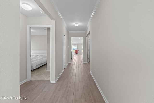 hall with crown molding, wood finished floors, and baseboards