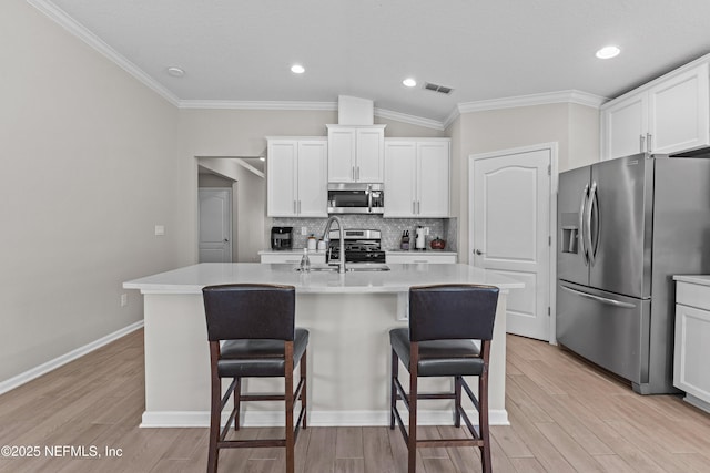 kitchen with tasteful backsplash, visible vents, a breakfast bar area, and stainless steel appliances