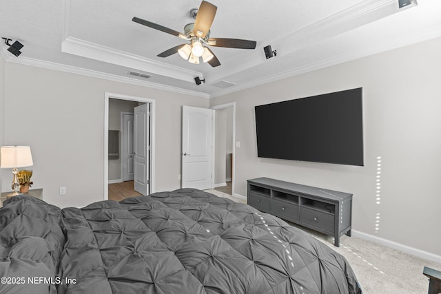 bedroom featuring visible vents, ornamental molding, a tray ceiling, carpet flooring, and baseboards