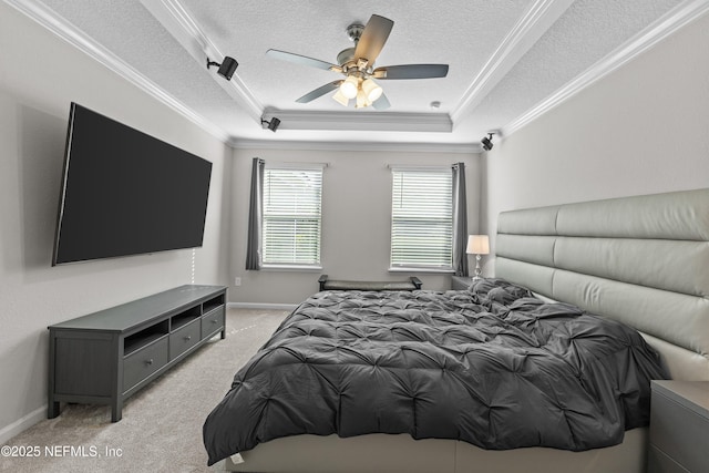 bedroom featuring a tray ceiling, light colored carpet, ornamental molding, and a textured ceiling