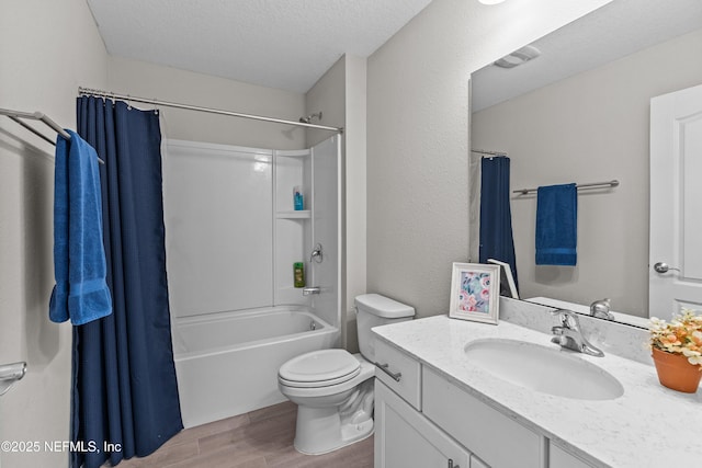 full bath with wood finish floors, toilet, shower / bath combo, a textured ceiling, and vanity