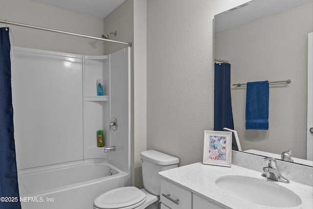 bathroom with vanity, toilet, a textured wall, and shower / bath combo