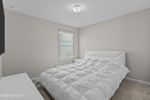 carpeted bedroom featuring baseboards and a textured ceiling