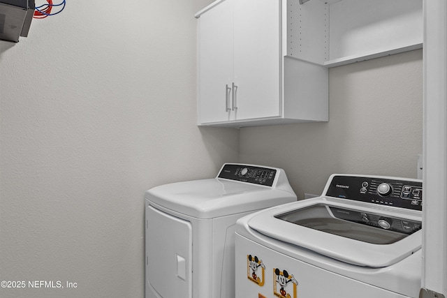 clothes washing area with cabinet space and independent washer and dryer