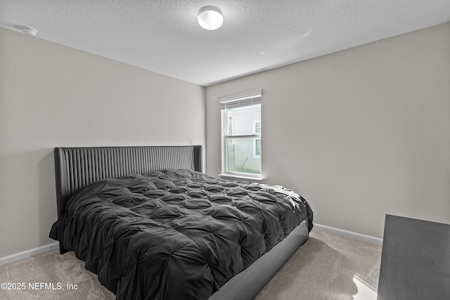 carpeted bedroom featuring baseboards and a textured ceiling